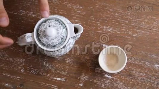 在木桌上用杯中的陈年茶点缓慢地饮用健康绿茶。 传统仪式视频
