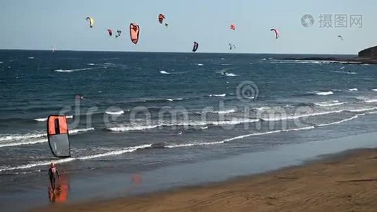 许多五颜六色的风筝在海滩上和风筝冲浪在大风天乘风破浪视频