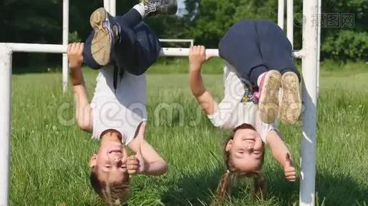 家庭运动。小男孩和小女孩在足球场上做运动，在单杠上做运动视频