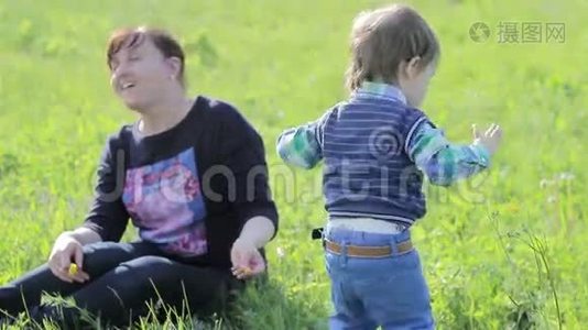 小男孩在公园里和他妈妈玩。视频
