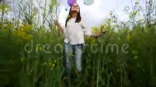 快乐的女孩带着气球在麦田里散步视频