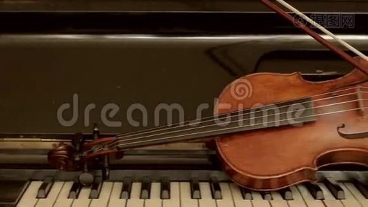 旧小提琴躺在钢琴上。视频