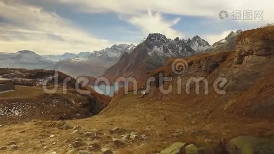 在秋天漫步，发现树林、山谷湖和雪上坐骑。 阳光明媚的秋日在五彩缤纷的红林中徒步旅行视频