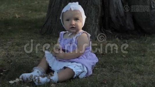 一个穿着白色袜子坐在草地上的女婴视频