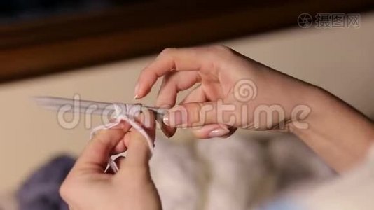 女`的手数着针上的纱线圈来编织。视频