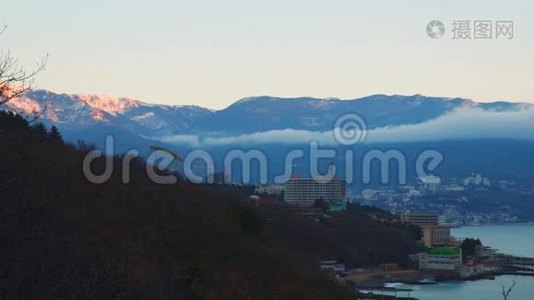 近海山脚下的城市.. 云层中的山顶。视频