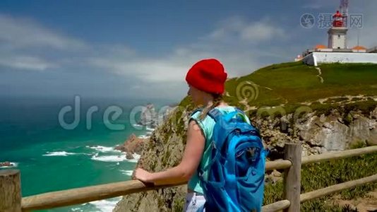 背着背包的女人可以欣赏灯塔附近的海洋海岸视频