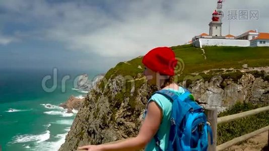 背着背包的女人可以欣赏灯塔附近的海洋海岸视频