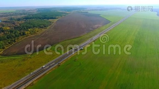 天景汽车沿着公路驶过绿色的田野。 汽车交通。 汽车车道视频