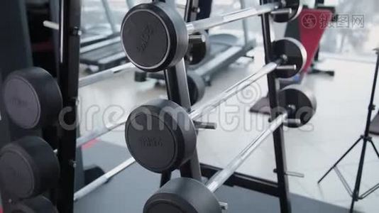 一组重量不同的重量在健身房的架子上。视频