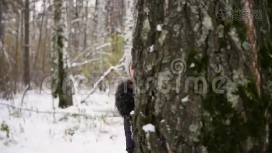 冬天公园里，女孩从树后扔雪球视频