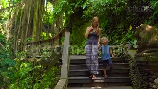 一名年轻女子和她的小儿子在印度尼西亚Ubud参观猴子森林生态公园的慢镜头视频
