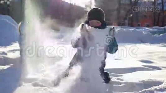 快乐的孩子在阳光明媚的一天在冬季公园玩得很开心。 把雪洒在自己身上视频