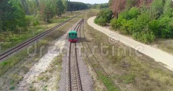 小火车头沿着森林里的铁路行驶，绿色火车头沿着森林路空中行驶视频