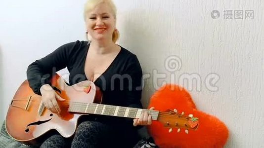 一个年轻的金发女孩唱歌弹吉他视频