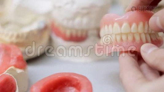 假牙在牙齿模型的背景下点击视频