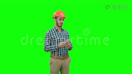 建筑工人用电话在绿色屏幕上拍摄自拍，铬键。视频