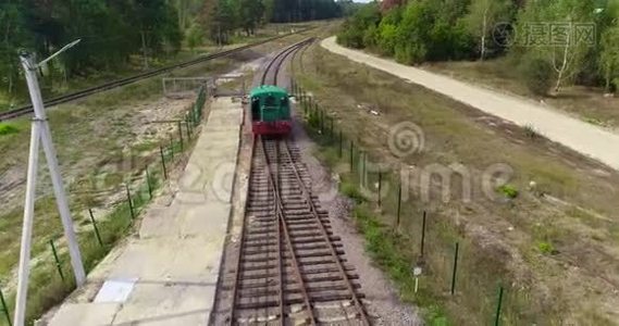 小火车头沿着森林里的铁路行驶，绿色火车头沿着森林路空中行驶视频