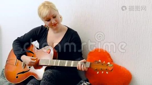 一个年轻的金发女孩唱歌弹吉他视频