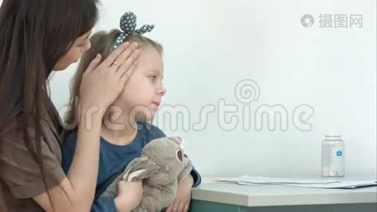 妈妈抱着小女孩，在医生办公室用体温计给她量体温视频