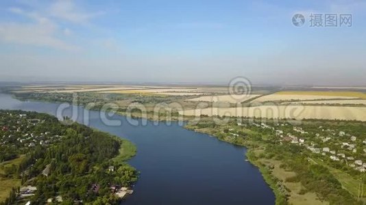 空中俯瞰蓝色河流，小村庄和河岸上的田野，无人驾驶飞机拍摄乡村夏季景观视频