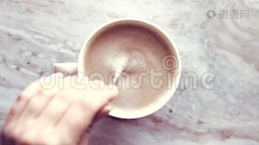 早晨的咖啡杯，牛奶放在大理石石板上，热饮放在桌子上，上面有食物录像和食谱视频