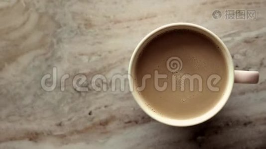 早晨的咖啡杯，牛奶放在大理石石板上，热饮放在桌子上，上面的食物图片和食谱视频