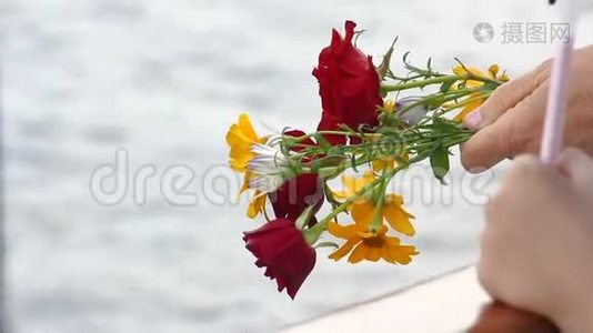 手捧一束玫瑰，放在水的背景上视频