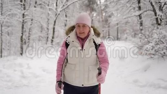 穿着漂亮运动服装的老年妇女在冬季森林的雪道上行走。 现代养恤金视频