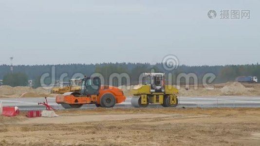 机场跑道道路、公路的施工、混凝土。 人，工人配合沥青摊铺机工作.. 道路压路机视频