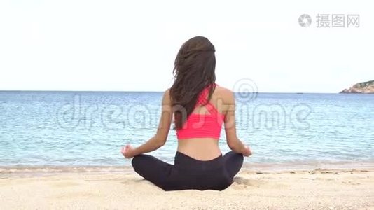 日落时分，年轻女子在海滩上练习瑜伽。 锻炼冷静与和谐.. 沉思于莲姿.. 健康视频