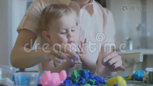 年轻迷人的保姆正在和婴儿玩塑料。 学前教育发展。视频