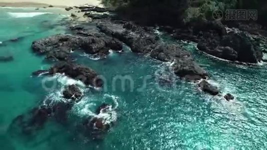从空中可以看到海浪撞击海滩附近的岩石。 无人机在危险的石头上射出海浪。视频