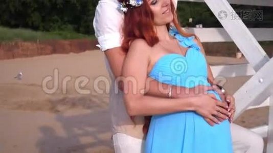 怀孕的夫妇抱着肚子。 穿着蓝色衣服抱着肚子的女人视频