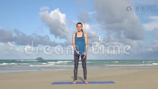 年轻女子在海前海滩平衡瑜伽运动。 健康活跃的生活方式理念..视频