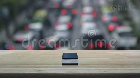 木制桌子上的现代智能手机屏幕上的问号标志图标，超过了城市中汽车和道路的高峰时间模糊，视频