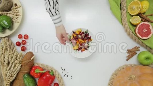 顶部的女人手拿盘子和沙拉，并把它放回去。 健康生活方式，饮食视频