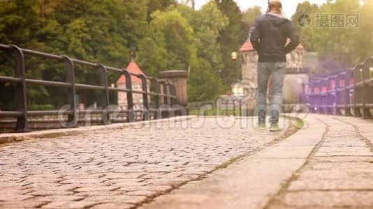 光学耀斑效应视频：一名男子沿着古老的历史大坝行走视频
