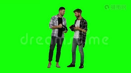 两个带虚拟现实耳机的年轻人。 绿色屏幕视频