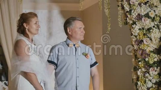 快乐的成年夫妻在花拱下结婚视频