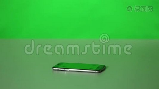一个iPhone和一个办公桌上的绿色屏幕。视频