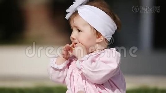 在阳光明媚的日子里，在公园里吃烤面包的可爱的小女孩的特写镜头。视频