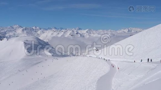 在滑雪场的雪山阳光明媚的一天，许多滑雪者山坡上视频