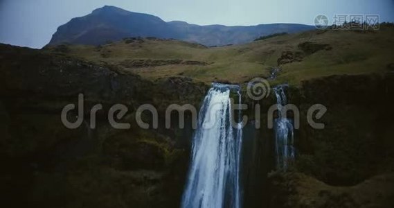 冰岛瀑布的鸟瞰图。 在河边飞行的直升机从山上掉下来。视频