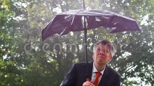 在雨中躲在破雨伞下的白人商人视频