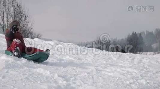 那男孩乘雪橇在山上爬下来视频