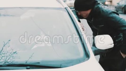 穿皮夹克的罪犯强迫女人坐在车里打开窗户视频