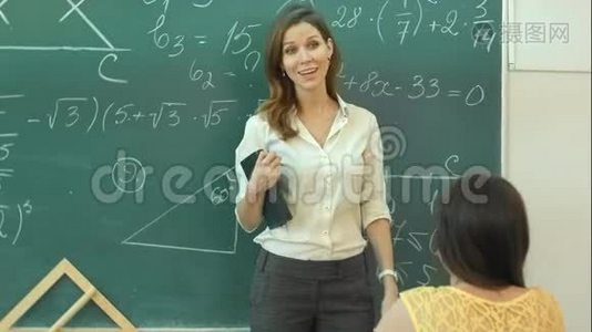 微笑老师在课堂上谈论绿色黑板上的数学任务视频
