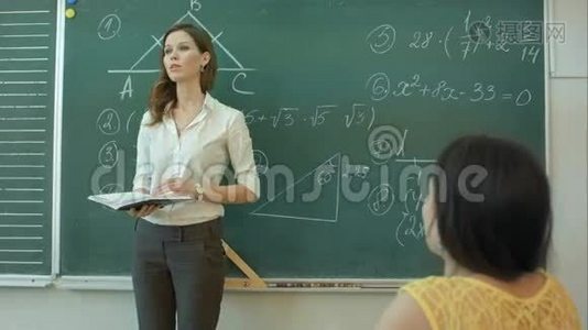 女人站在教室的绿色黑板上视频