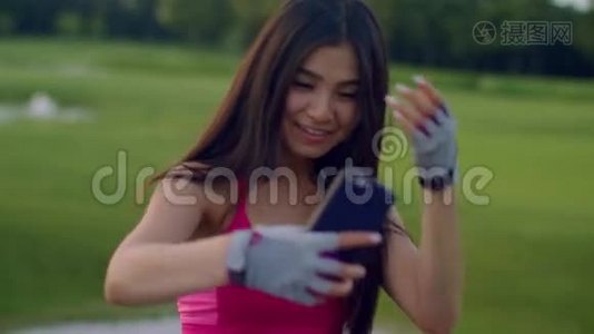 亚洲女孩在公园自拍。 运动女孩在公园打电话自拍视频